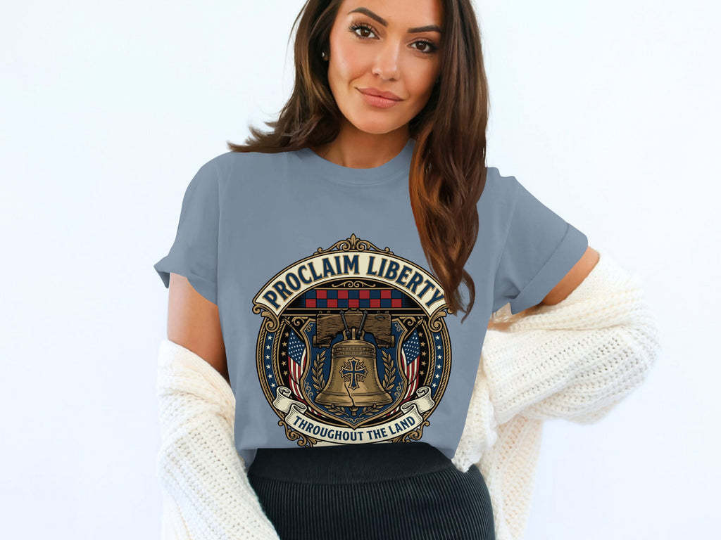 Woman wearing gray t-shirt with "Proclaim Liberty" bell emblem.