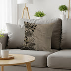 Beige throw pillow with tropical leaf pattern on a gray sofa.