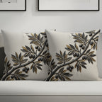 Two cream throw pillows with embossed gold and black olive branches.