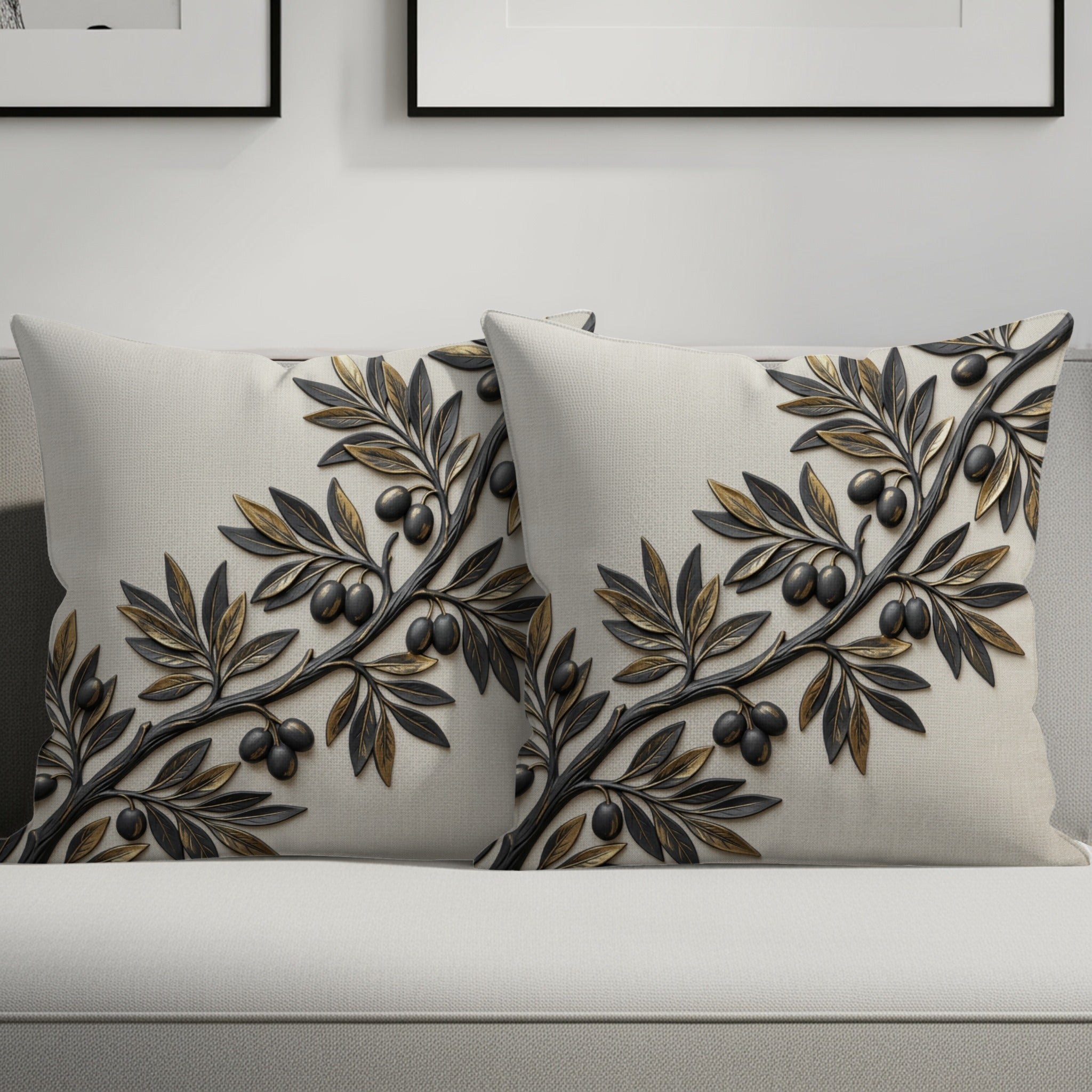 Two cream throw pillows with embossed gold and black olive branches.