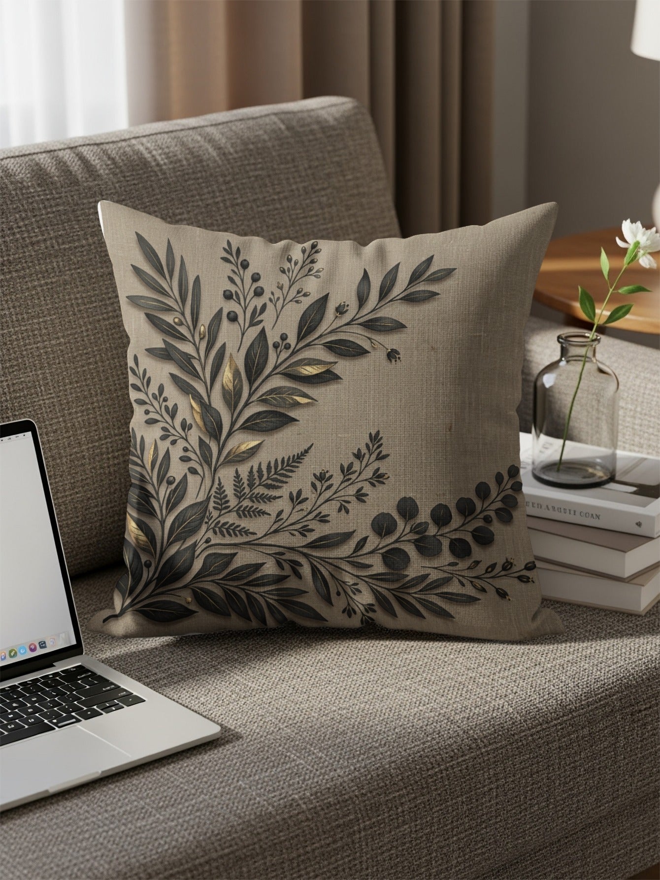 Beige throw pillow with dark botanical leaf pattern on sofa.