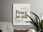 Wall art with "Peace be still" text and olive branches.