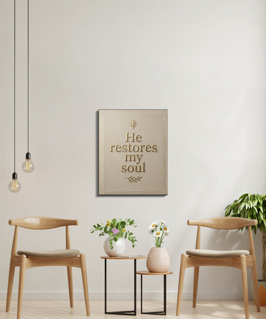 Canvas wall art with text "He restores my soul" above two chairs and small tables.