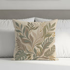 Decorative square pillow with a botanical leaf design in muted greens and beige.