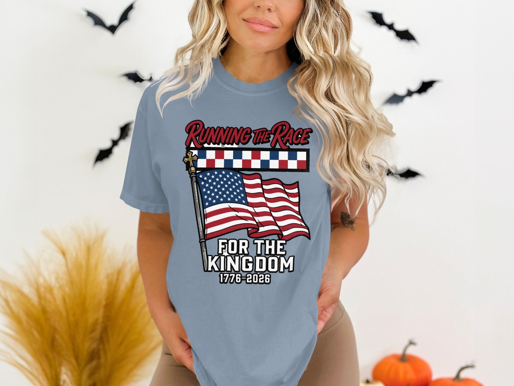 Woman wearing a blue t-shirt with "Running the Race for the Kingdom 1776-2026" and an American flag.
