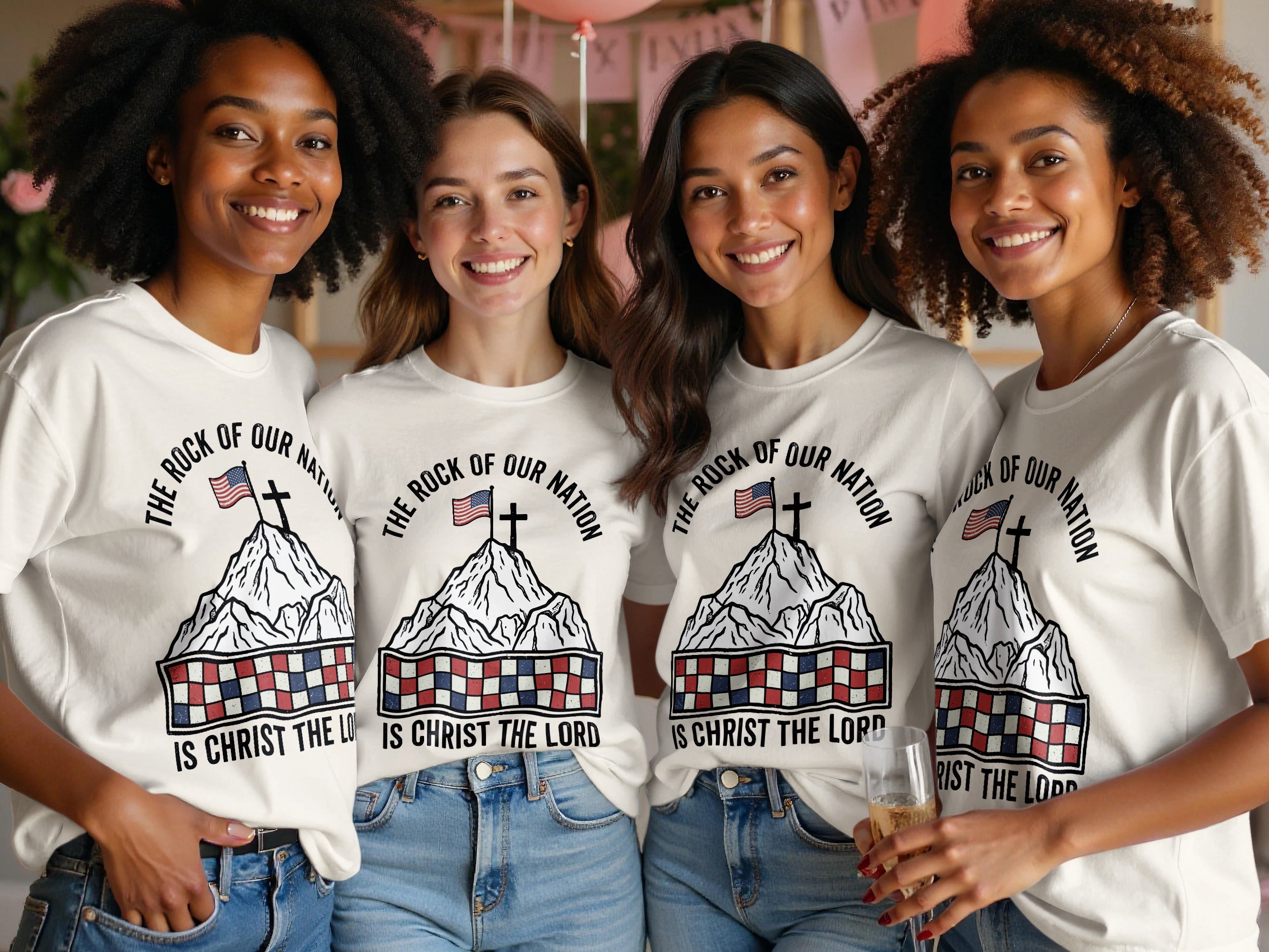 Four women wearing t-shirts with a patriotic design and text "The Rock of Our Nation Is Christ the Lord."