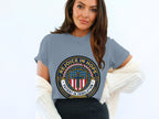 Gray t-shirt with circular emblem saying "Rejoice in Hope, Patient in Tribulation"