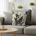 Decorative pillow with botanical fern and leaf print on gray sofa.