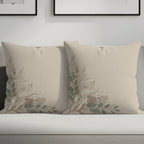 Two neutral beige pillows with delicate floral branch embroidery in earthy tones.