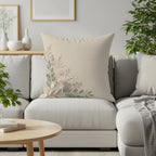 Beige throw pillow with a delicate floral corner design on a sofa.