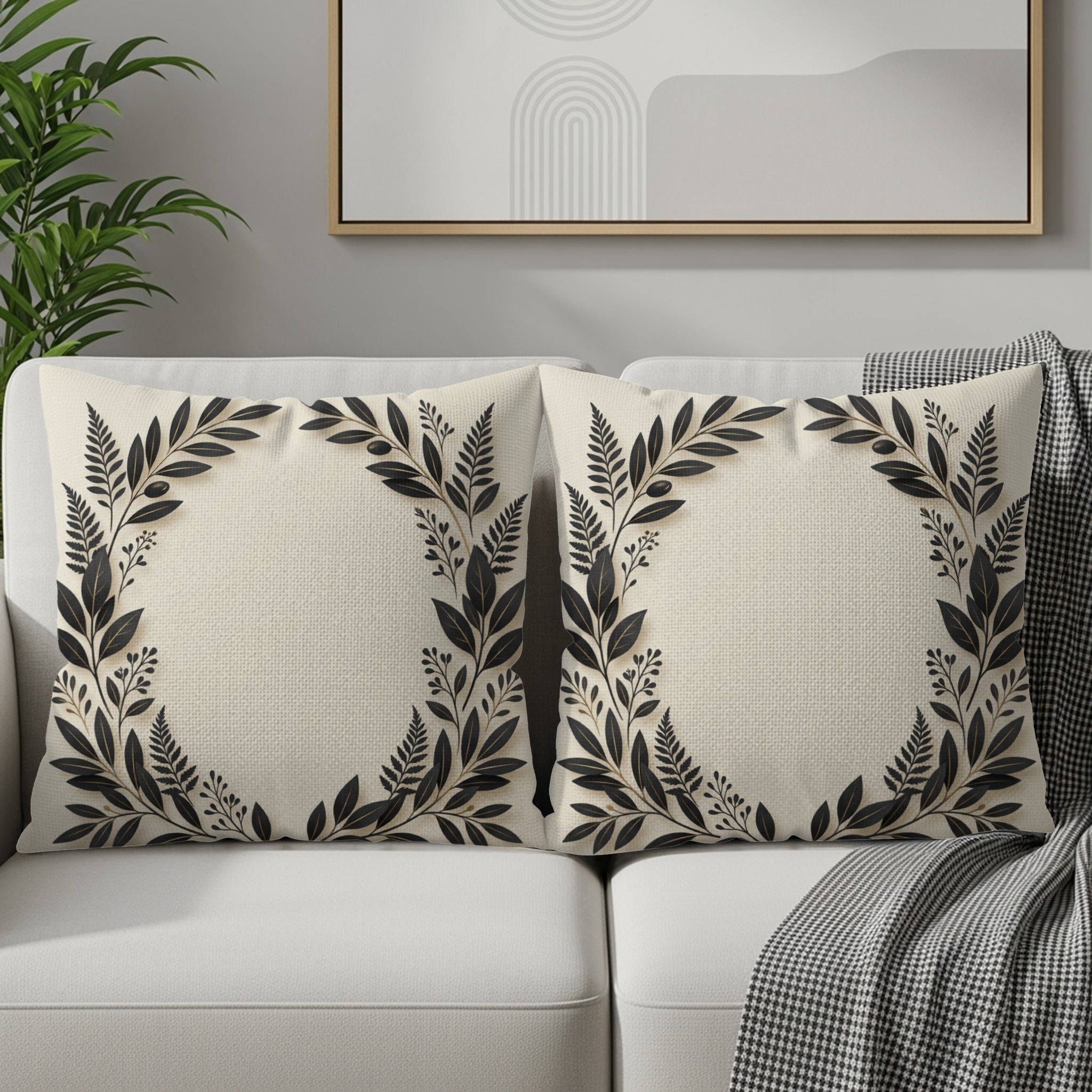 Two square decorative pillows with a dark floral wreath design on a cream background.
