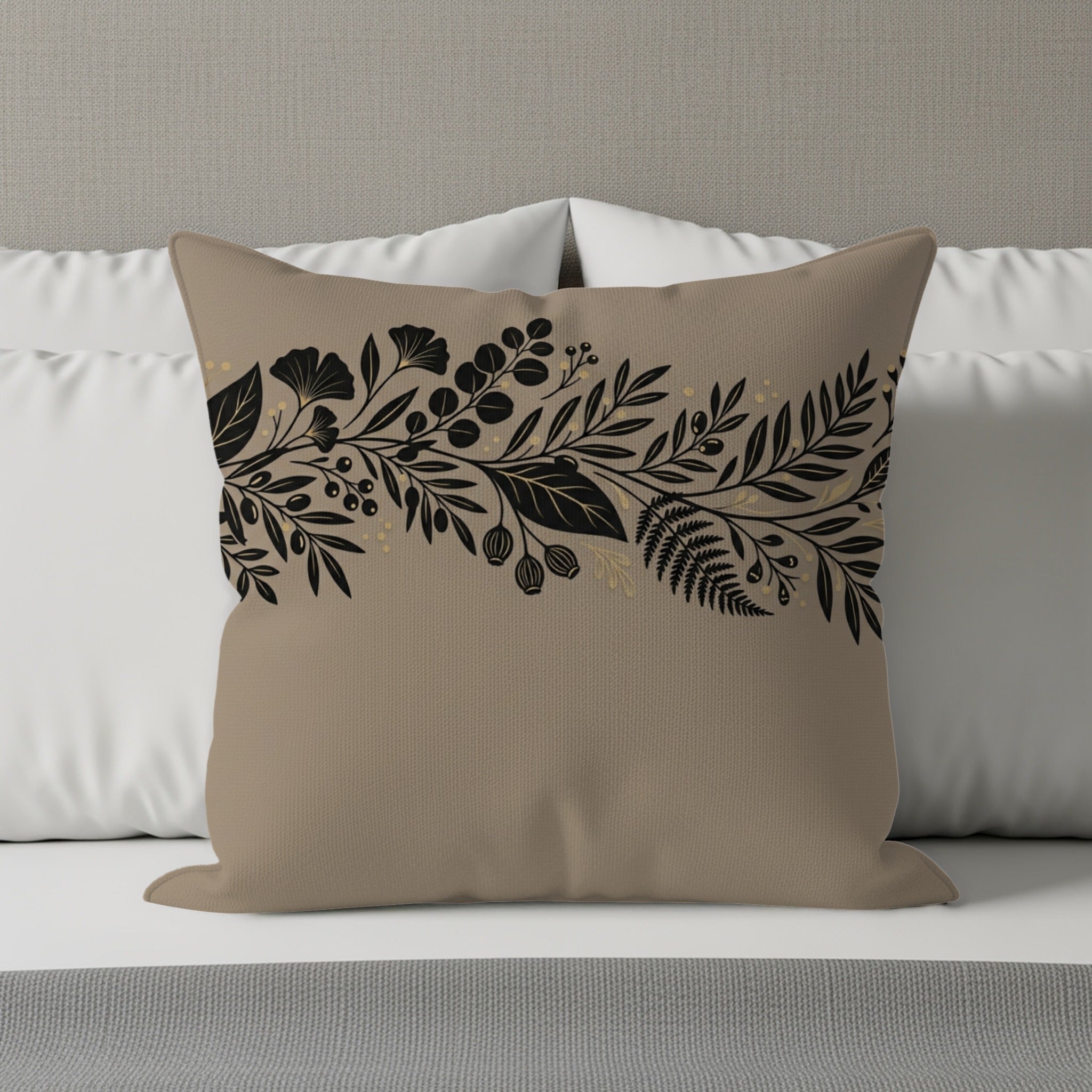Tan throw pillow with black floral and leaf vine pattern.