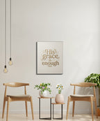 "His grace is enough" sign above a small table with vases between two chairs.
