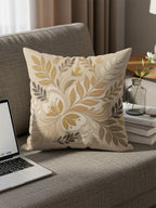 Beige throw pillow with tan and brown floral pattern on couch.