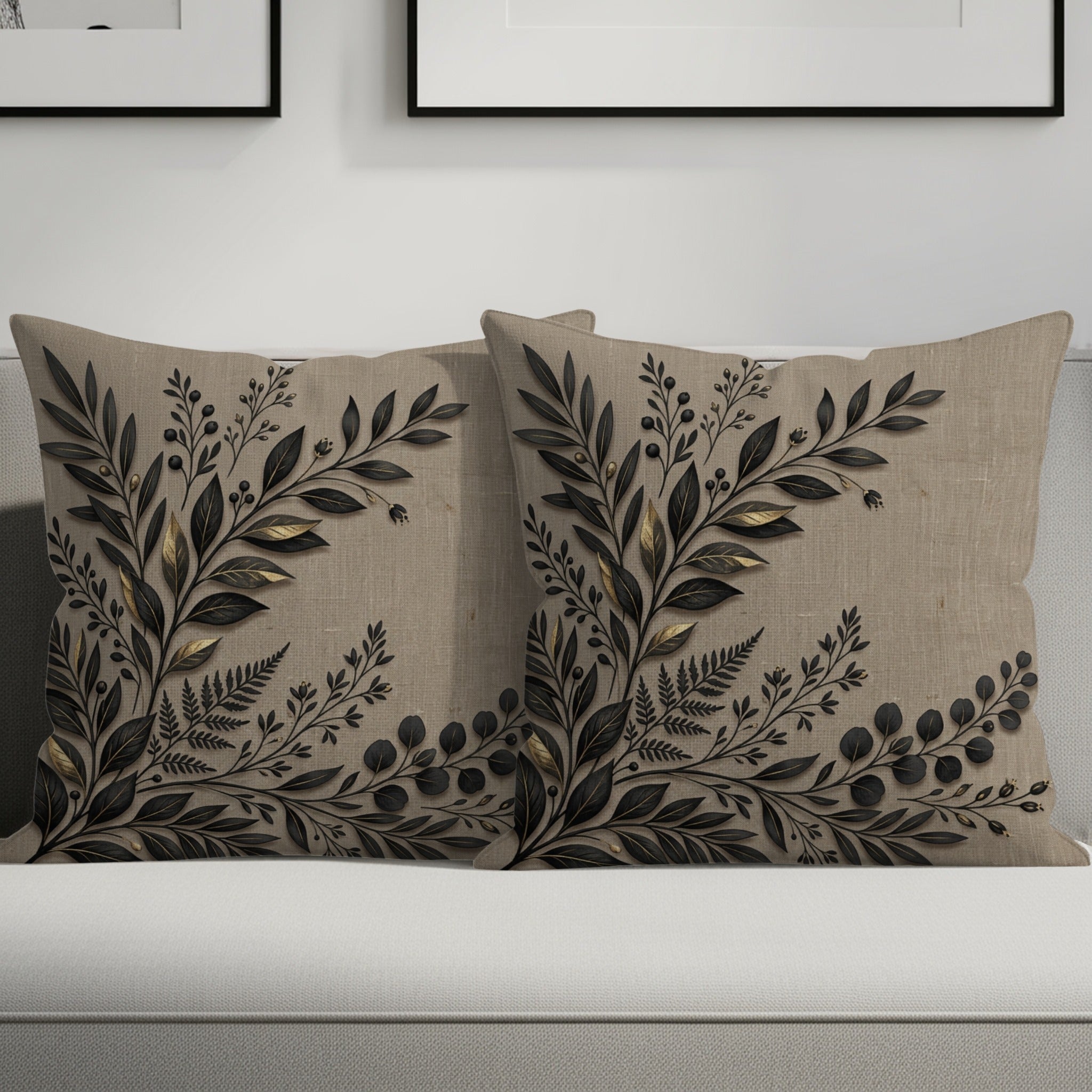 Two decorative linen throw pillows with black and gold botanical leaf design.