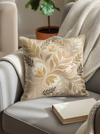 Square throw pillow with a neutral floral pattern on a chair.