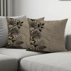 Two throw pillows with a tropical botanical print on a gray sofa.