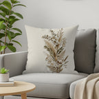 Pillow with botanical dried floral arrangement on a gray couch.