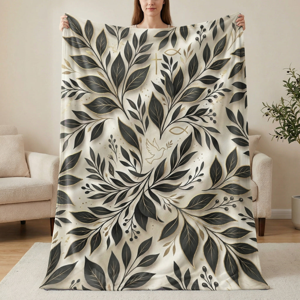 Cream blanket with gold and black botanical leaf pattern and subtle religious symbols.