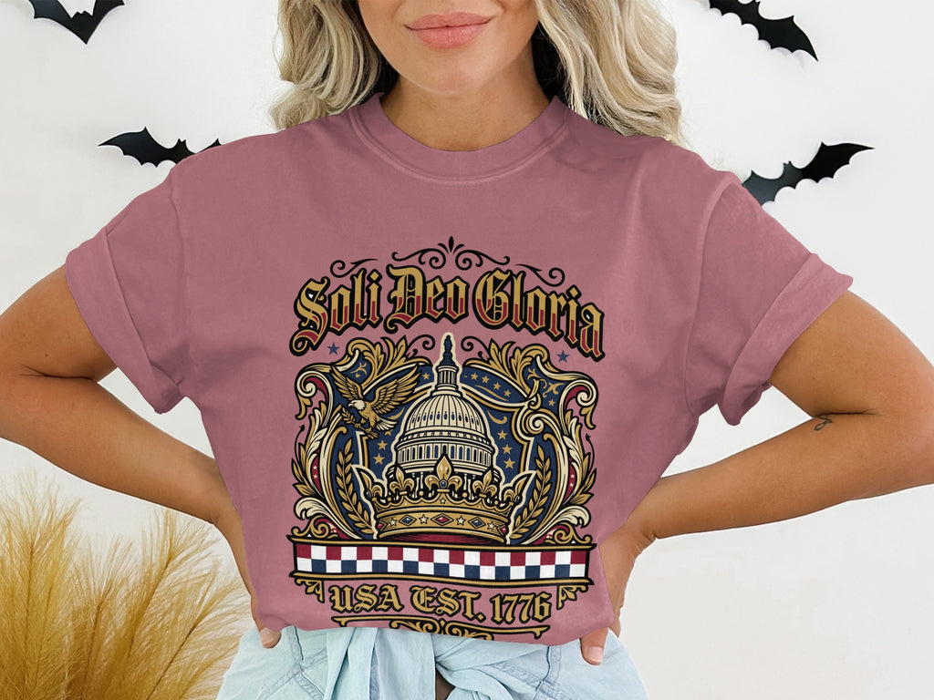 T-shirt with "Soli Deo Gloria" and "USA EST. 1776" text and patriotic eagle design.