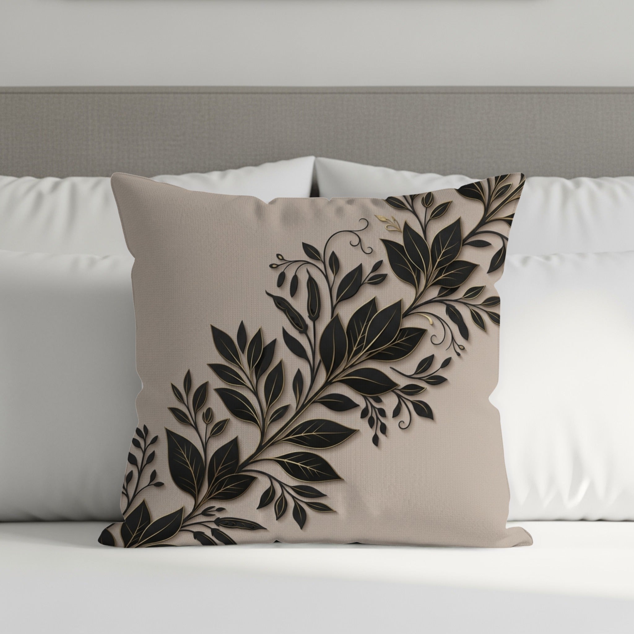 Beige throw pillow with black and gold floral leaf design.