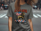 T-shirt with lion wearing crown, holding flag, with text "ALPHA & OMEGA 1776 2026".
