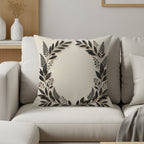 Cream cushion with a black floral wreath design.