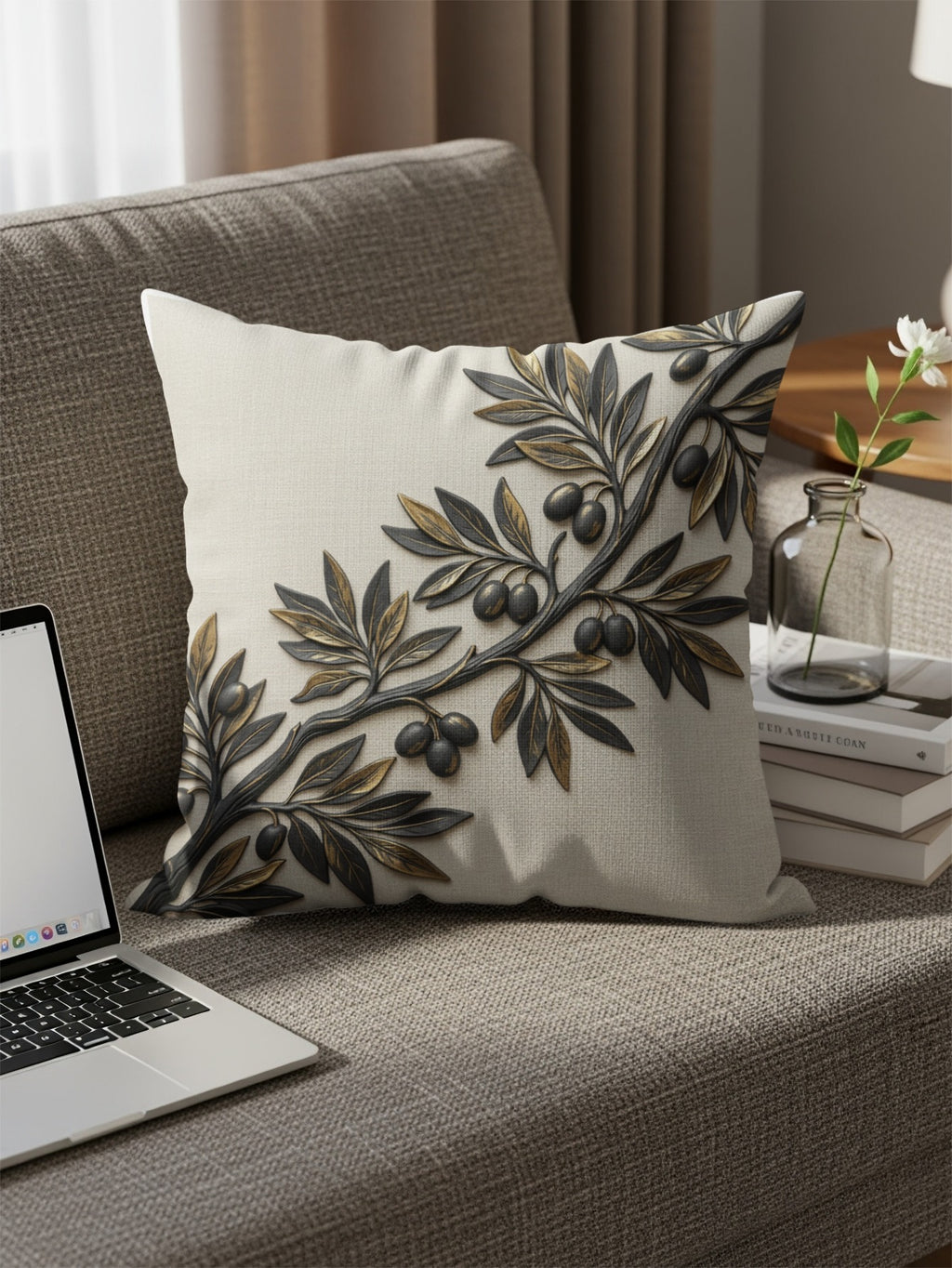 Pillow with embossed olive branch and olives on a couch.