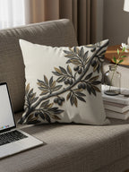 Pillow with embossed olive branch and olives on a couch.