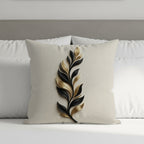 Beige pillow with black and gold abstract leaf design.