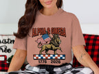 Lion wearing a crown holding an American flag, with "ALPHA & OMEGA" and "1776 2026" text.
