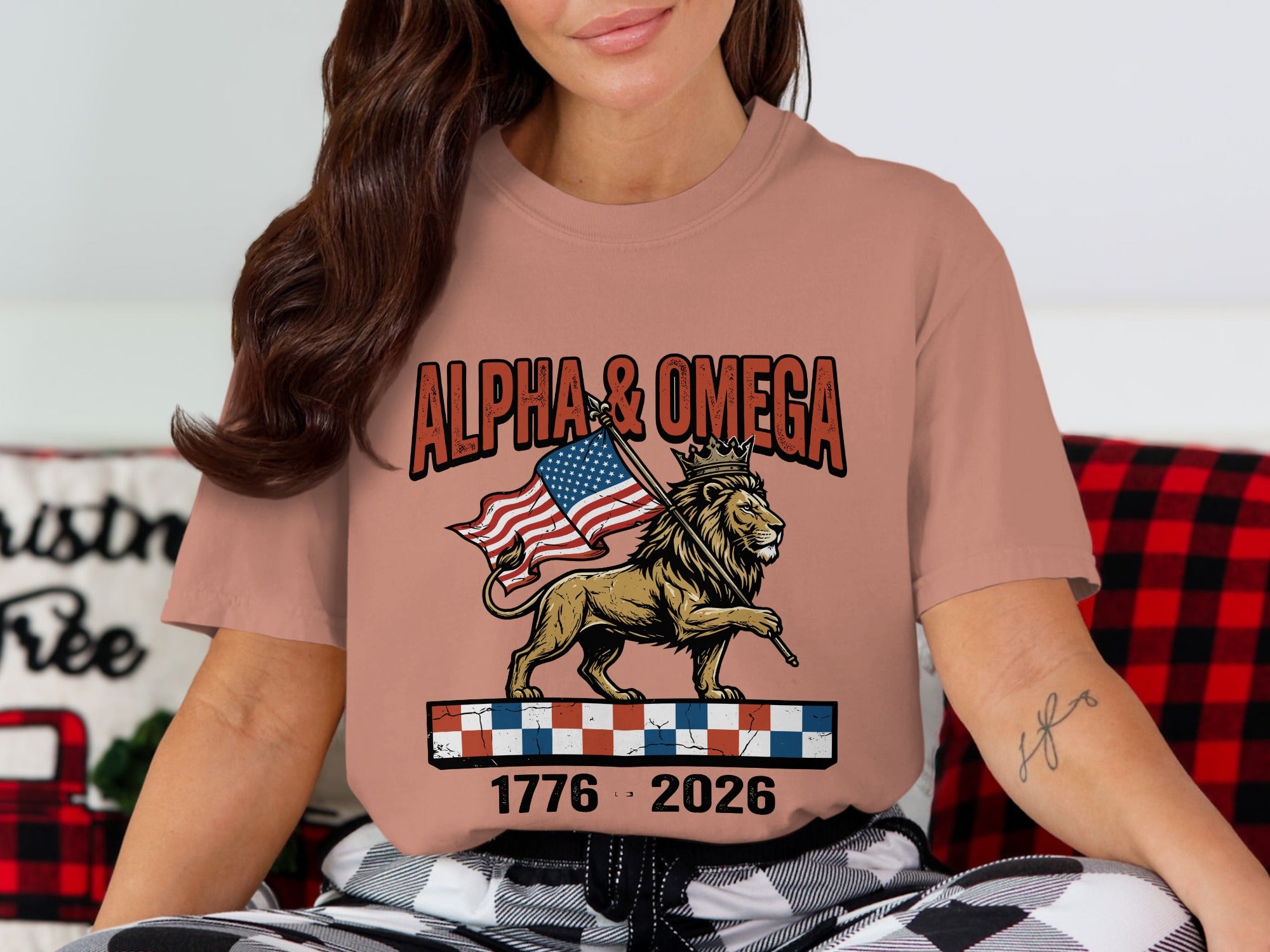 Lion wearing a crown holding an American flag, with "ALPHA & OMEGA" and "1776 2026" text.