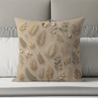 Beige decorative pillow with botanical leaf and flower pattern.