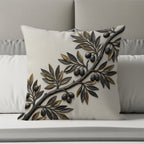 Embroidered olive branch with dark olives on a textured cream pillow.