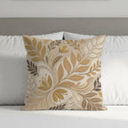 Square decorative pillow with tan floral and leaf pattern on bed.