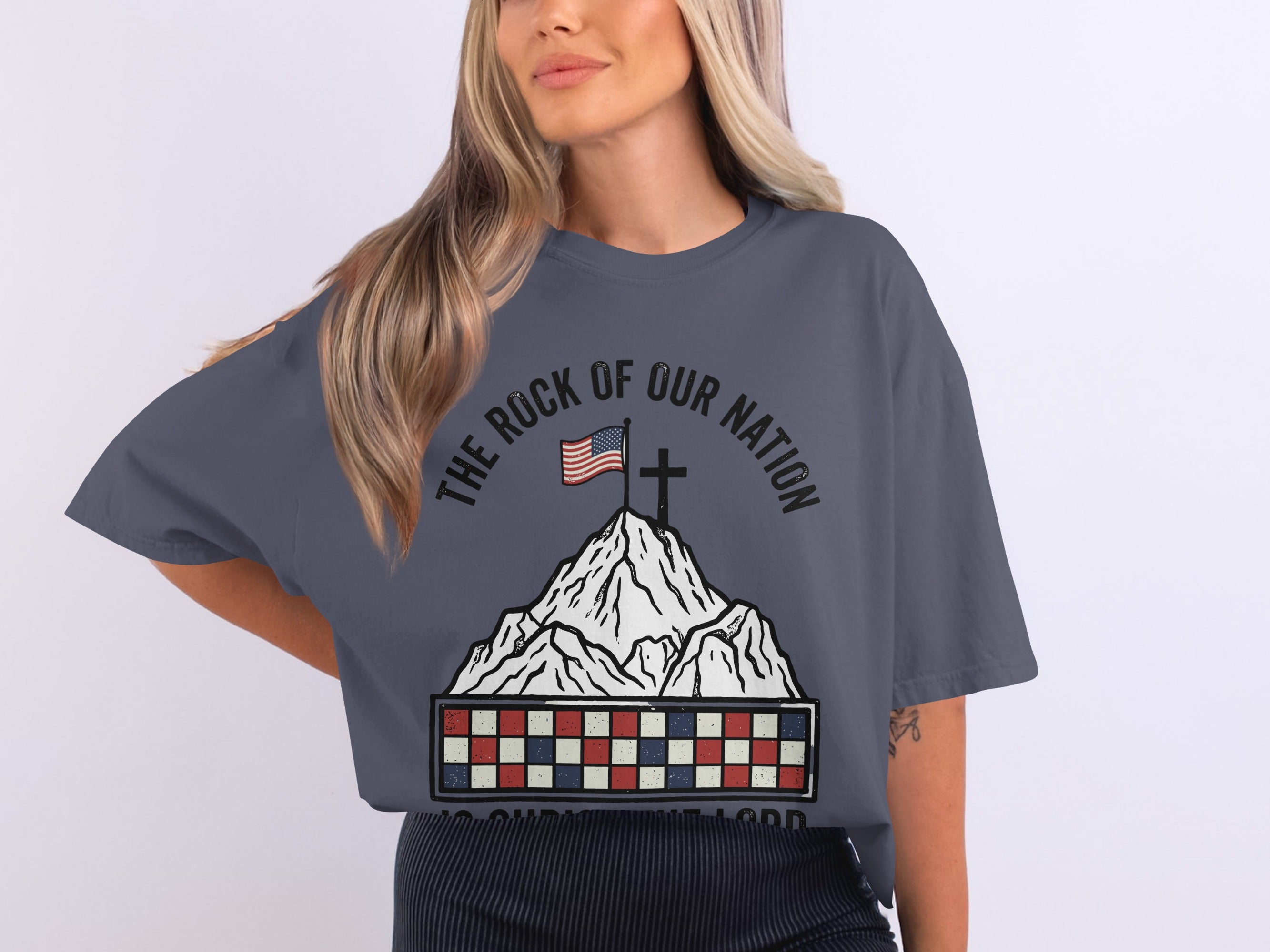 T-shirt with American flag, cross, and "The Rock of Our Nation" text on mountain.