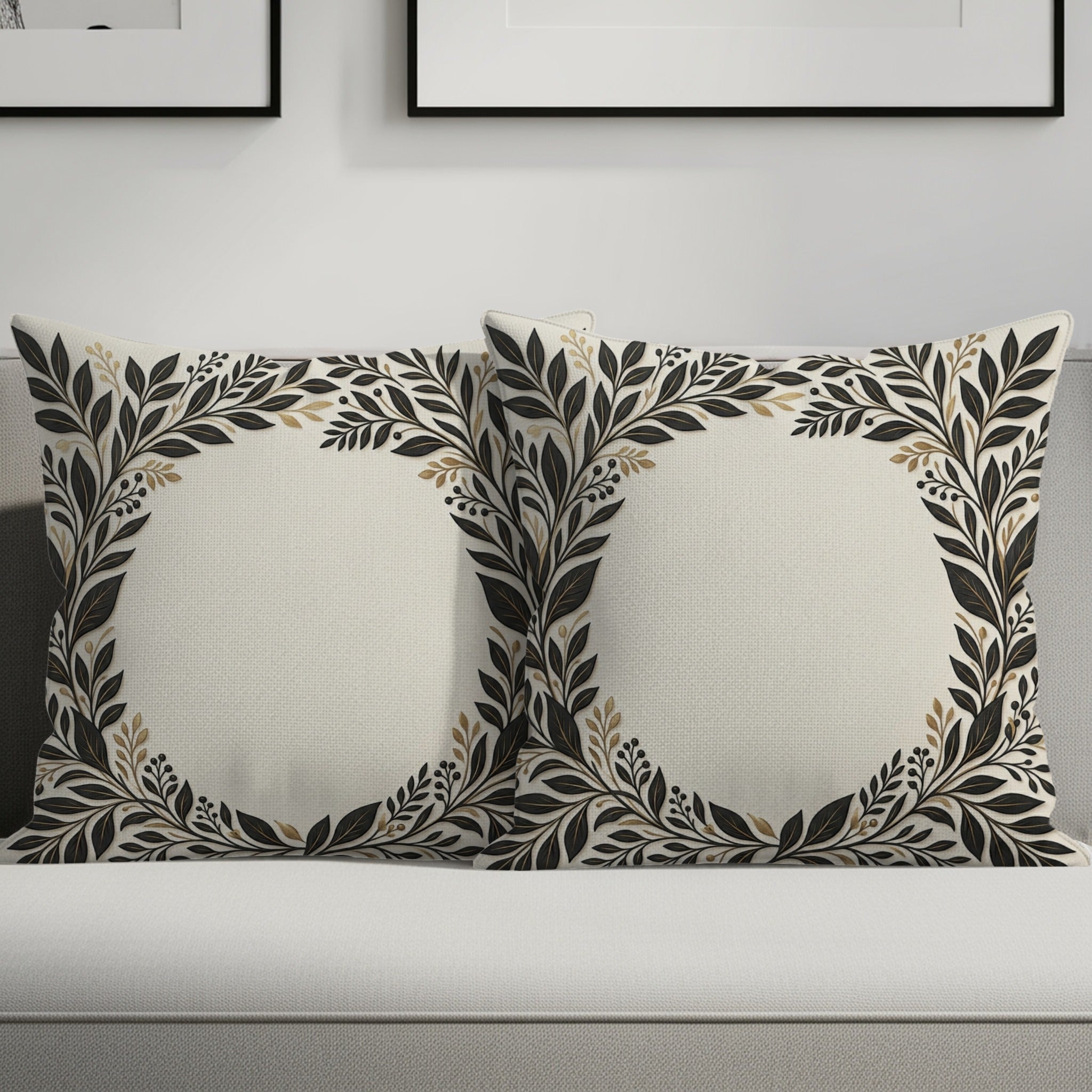 Two square throw pillows with a cream background and dark floral leaf border.