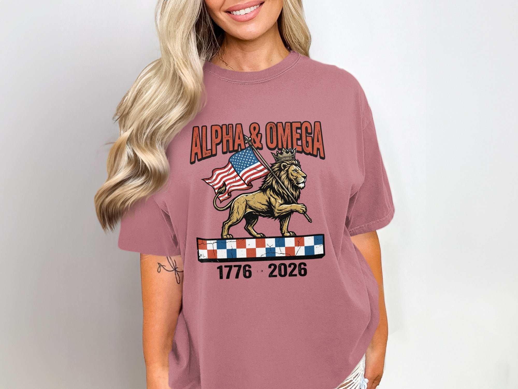 T-shirt with lion wearing crown, holding US flag, with ALPHA & OMEGA text.