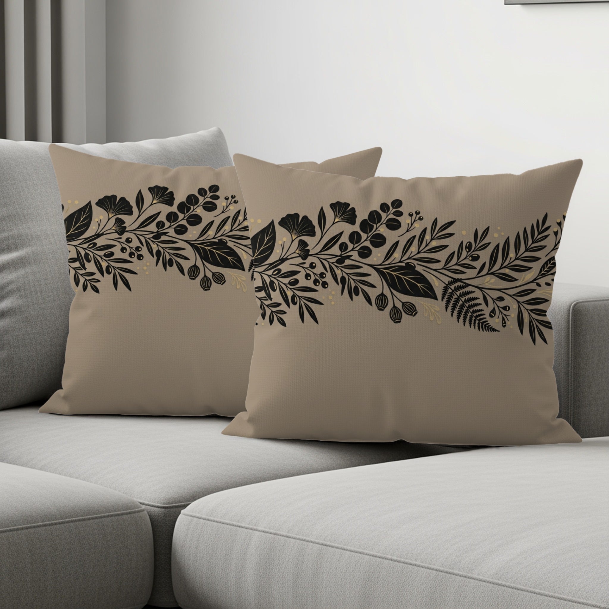 Two beige throw pillows with black and gold floral border patterns.