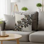 Cushion with a metallic olive branch design on a gray sofa.