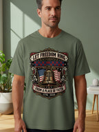 T-shirt graphic with American flag, bell, and patriotic text.