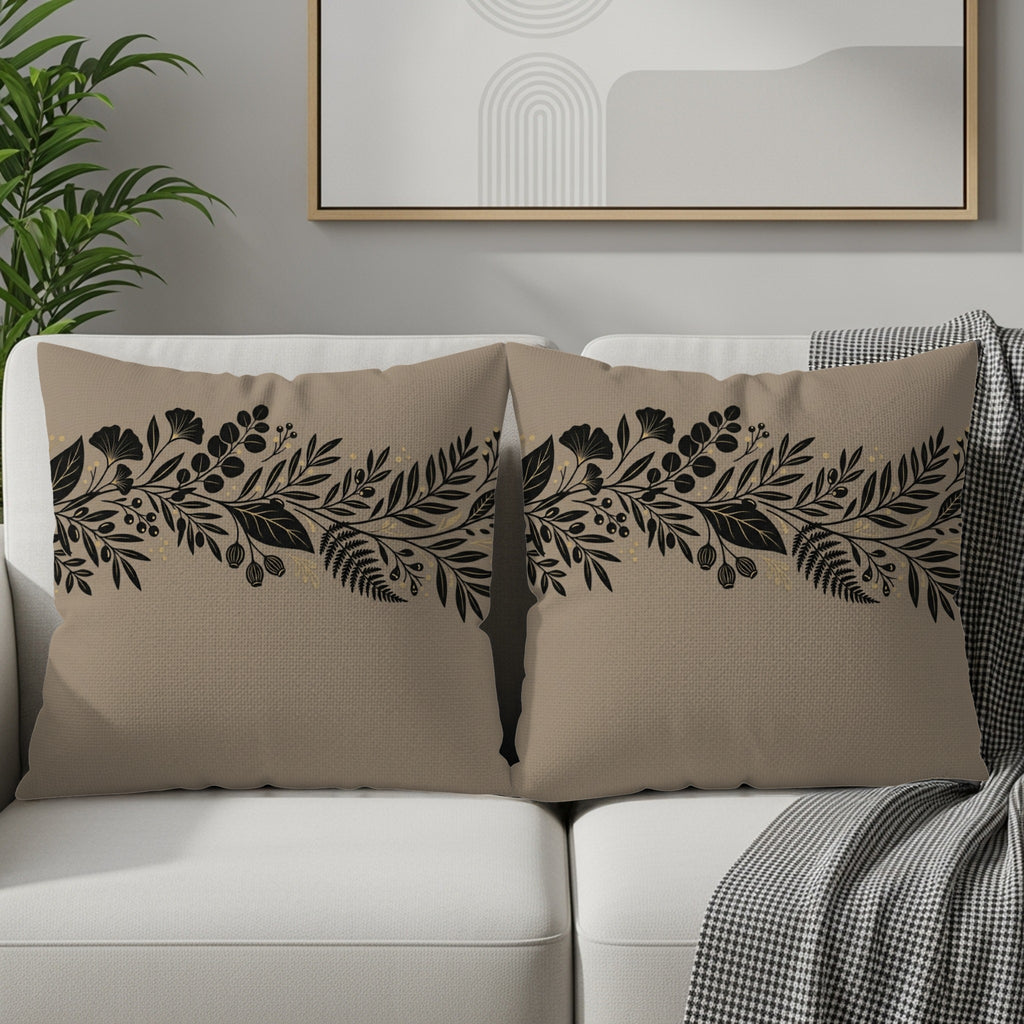 Tan throw pillows with black floral border design on a sofa.