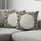 Two decorative throw pillows with a floral wreath pattern on a couch.