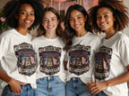 Four women wear matching white t-shirts with patriotic bell graphic and text.