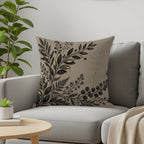 Tan throw pillow with ornate black and gold leaf design on couch.