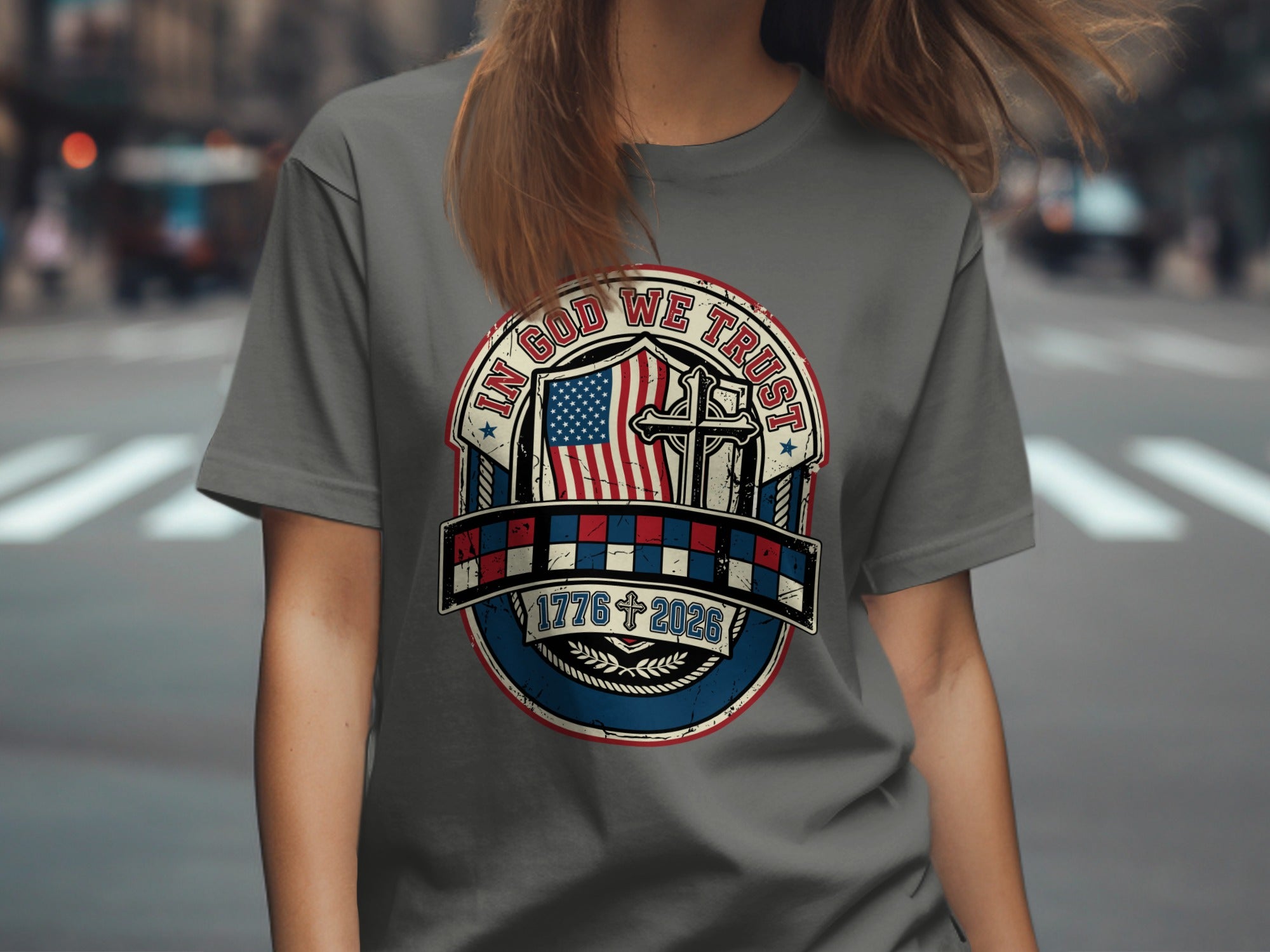Gray t-shirt with circular patriotic design featuring US flag, cross, and dates 1776-2026.