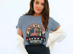 Woman wearing a patriotic t-shirt with American flag and cross graphic.