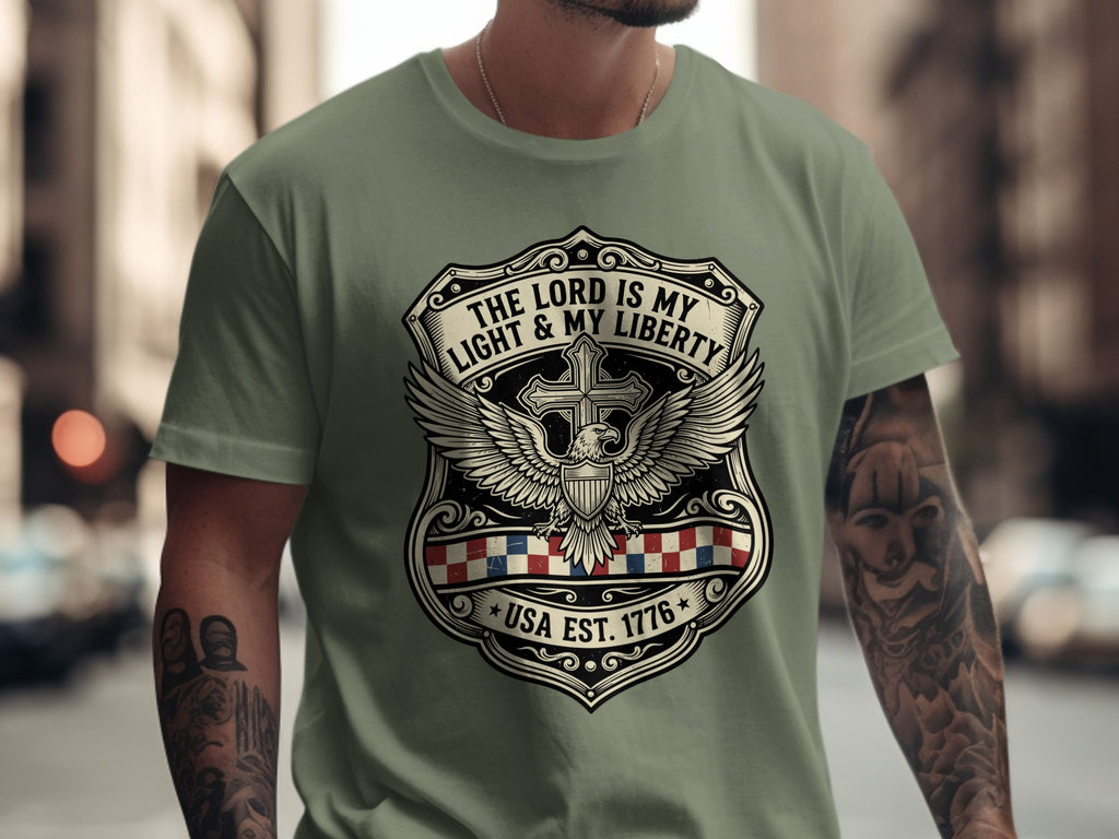 Green t-shirt with shield, eagle, and "The Lord is My Light & Liberty USA Est. 1776" text.