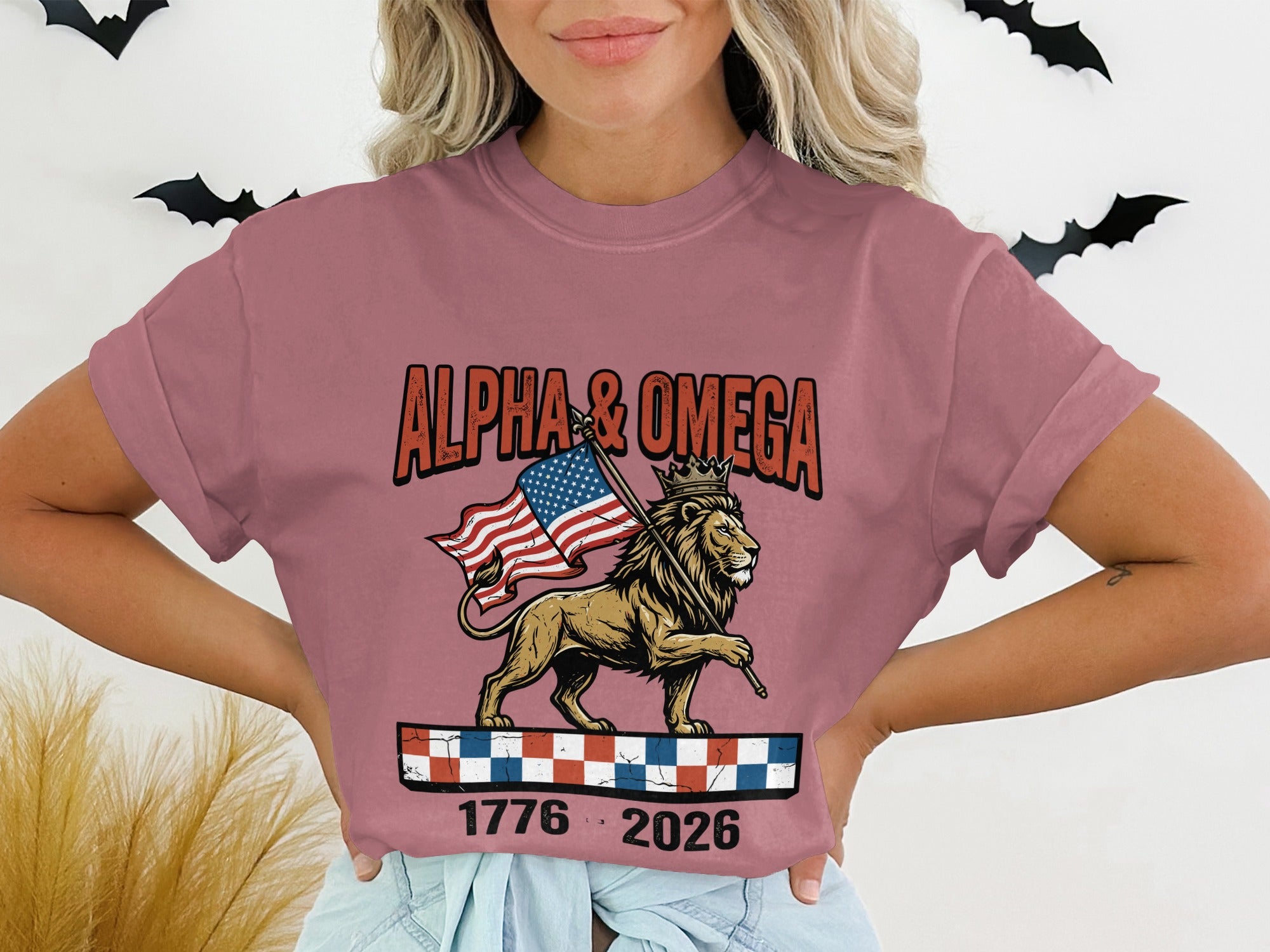 Lion holding American flag, "ALPHA & OMEGA 1776 2026" text.