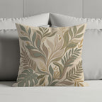Decorative throw pillow with a muted botanical leaf pattern on a bed.